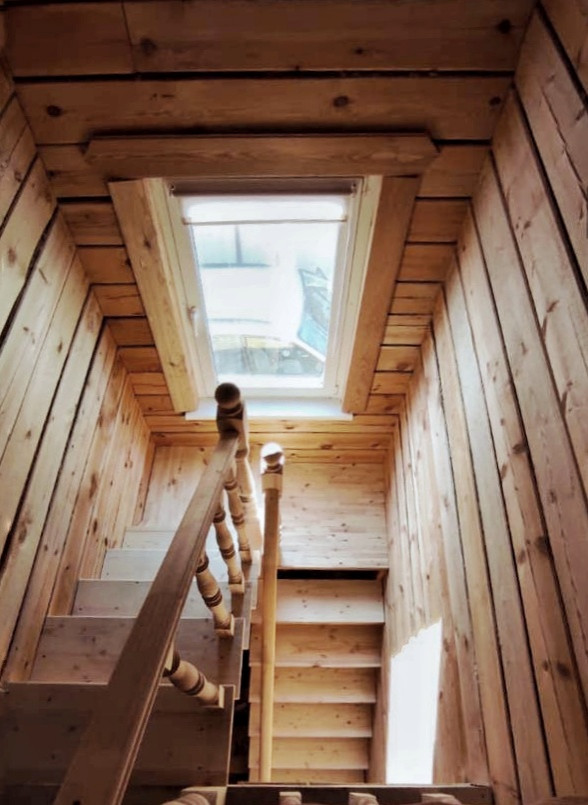 На фото: п-образная деревянная лестница среднего размера в классическом стиле с деревянными ступенями, деревянными перилами и деревянными стенами