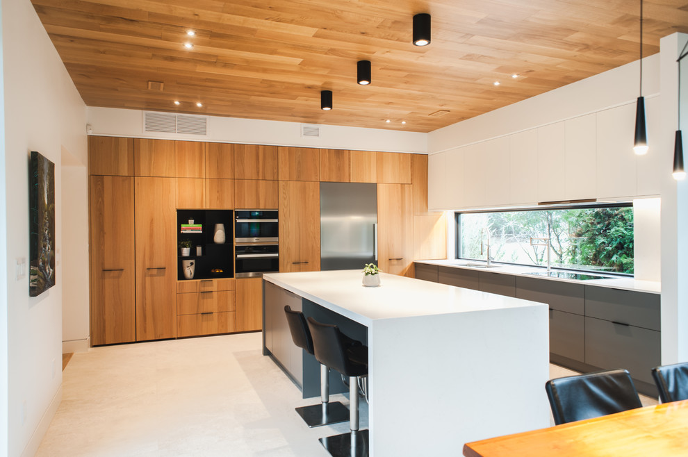 This is an example of a contemporary l-shaped kitchen in Toronto with an undermount sink, flat-panel cabinets, quartzite benchtops, white splashback, stainless steel appliances, travertine floors, with island and white floor.