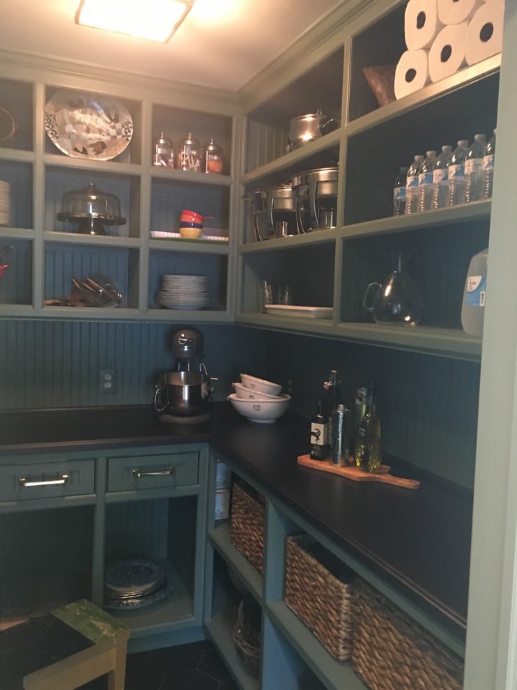Photo of a mid-sized traditional u-shaped kitchen pantry in DC Metro with beaded inset cabinets, green cabinets, wood benchtops, green splashback, timber splashback, ceramic floors, no island and black floor.