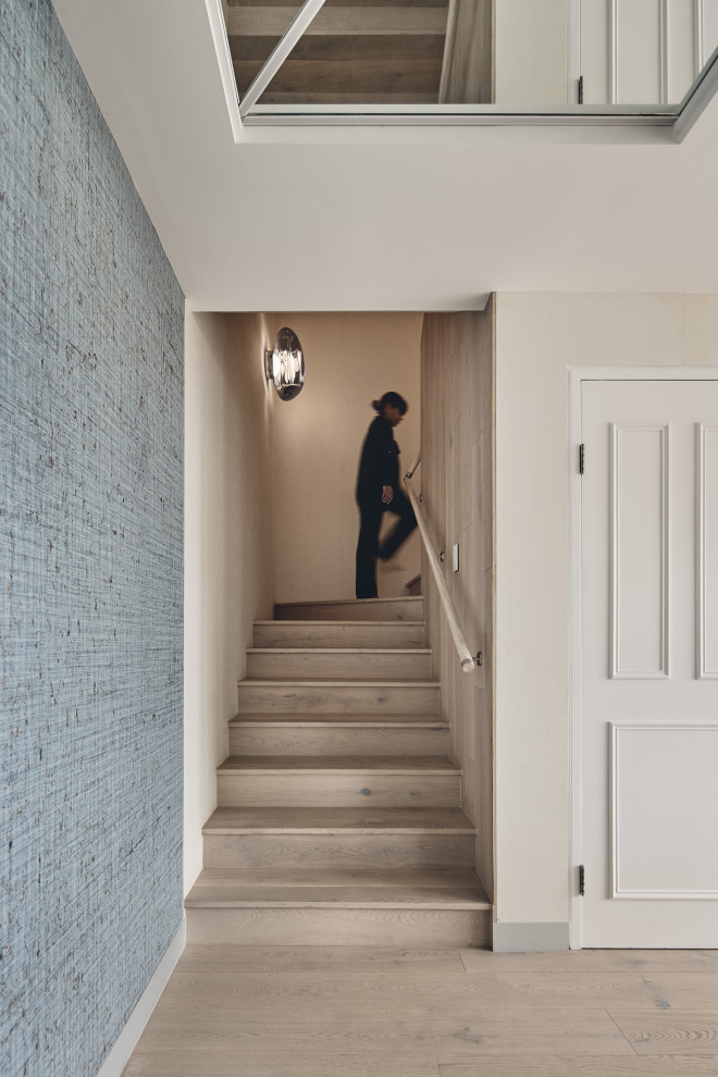 Aménagement d'un escalier classique en U avec des marches en bois, des contremarches en bois, un garde-corps en bois et du papier peint.