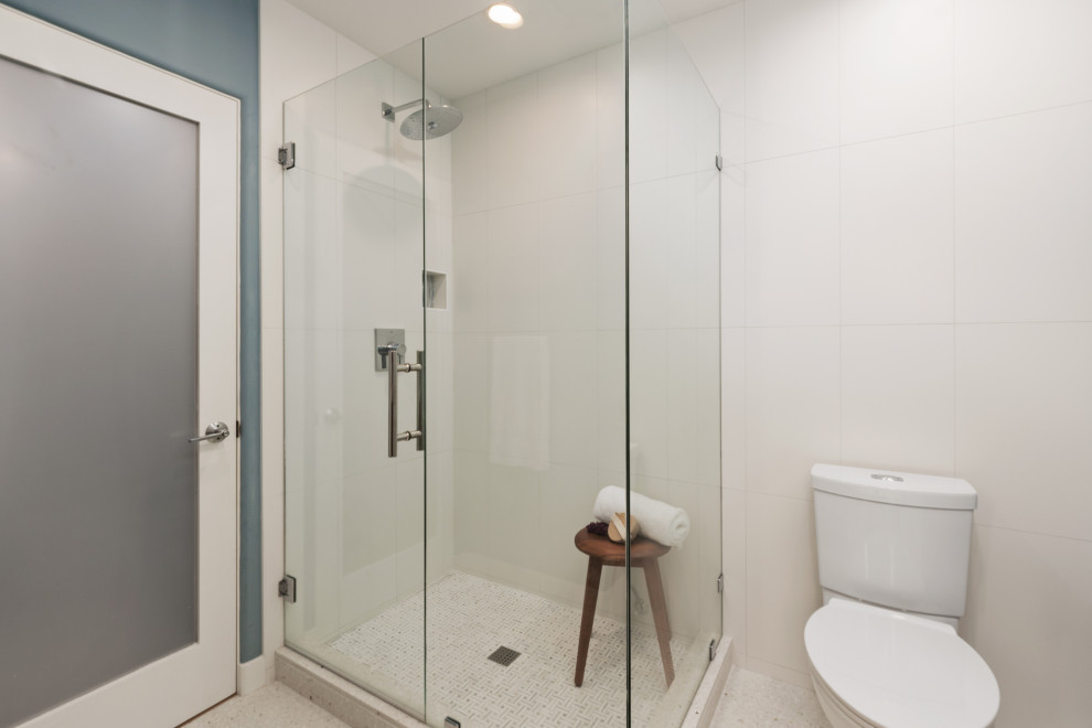 Cette image montre une très grande salle d'eau vintage en bois brun avec un placard à porte plane, une douche d'angle, WC à poser, un carrelage bleu, des carreaux de céramique, un mur bleu, un sol en terrazzo, un lavabo encastré, un plan de toilette en quartz modifié, un sol beige, une cabine de douche à porte battante, un plan de toilette blanc, meuble simple vasque et meuble-lavabo suspendu.