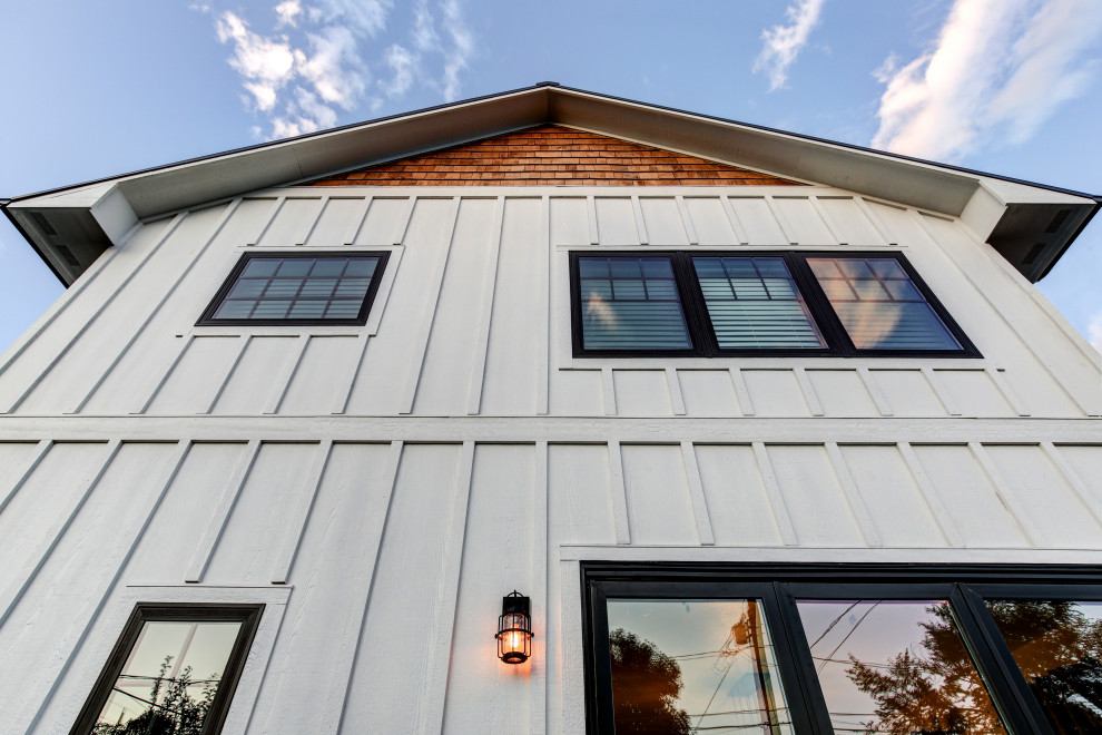 Example of a mid-sized farmhouse white two-story wood gable roof design in Denver with a metal roof