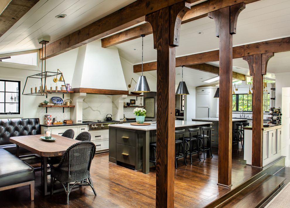 Inspiration for a country u-shaped eat-in kitchen in Atlanta with shaker cabinets, white cabinets, white splashback, stone slab splashback, stainless steel appliances, dark hardwood floors, multiple islands, brown floor and black benchtop.