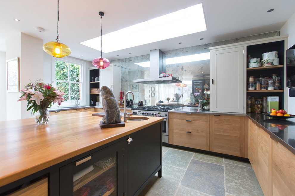 Large contemporary u-shaped open plan kitchen in Surrey with an integrated sink, shaker cabinets, black cabinets, stainless steel benchtops, metallic splashback, glass tile splashback, stainless steel appliances, terrazzo floors and with island.