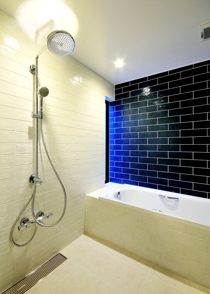 Photo of a contemporary bathroom in Other with a drop-in tub, multi-coloured walls, beige tile, white tile and black tile.