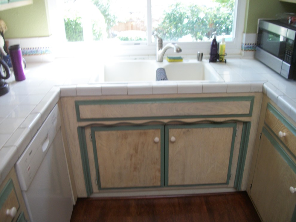 Mid-sized transitional u-shaped dark wood floor eat-in kitchen photo in Sacramento with raised-panel cabinets, white cabinets, tile countertops, white backsplash, ceramic backsplash, black appliances, a peninsula and a double-bowl sink