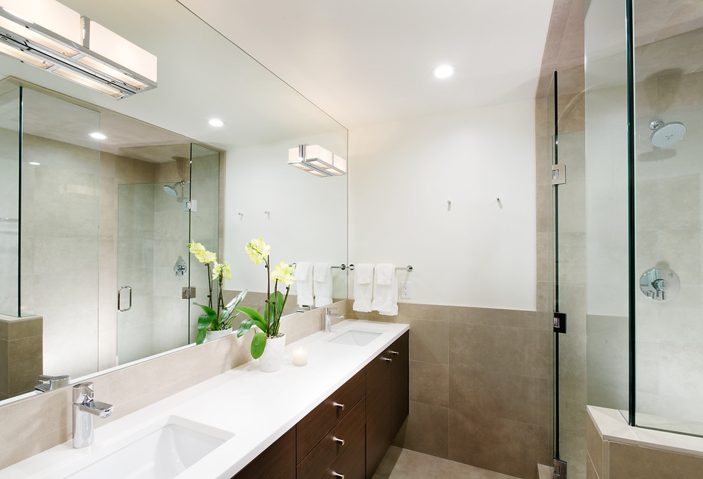 This is an example of a large contemporary master bathroom in Denver with an integrated sink, flat-panel cabinets, dark wood cabinets, solid surface benchtops, a corner shower, beige tile, porcelain tile and white walls.