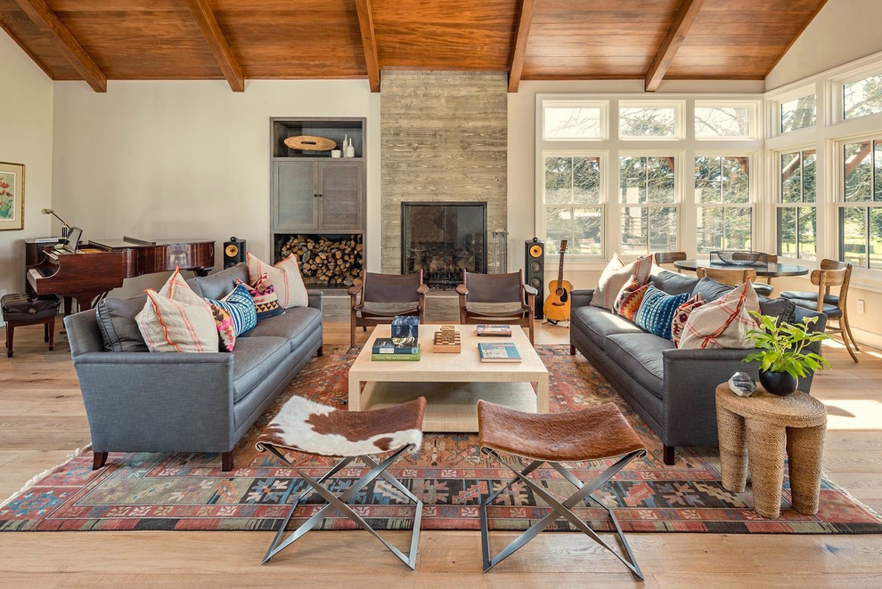 Inspiration for a large country open concept living room in San Francisco with white walls, light hardwood floors, a standard fireplace, a concrete fireplace surround, no tv and brown floor.