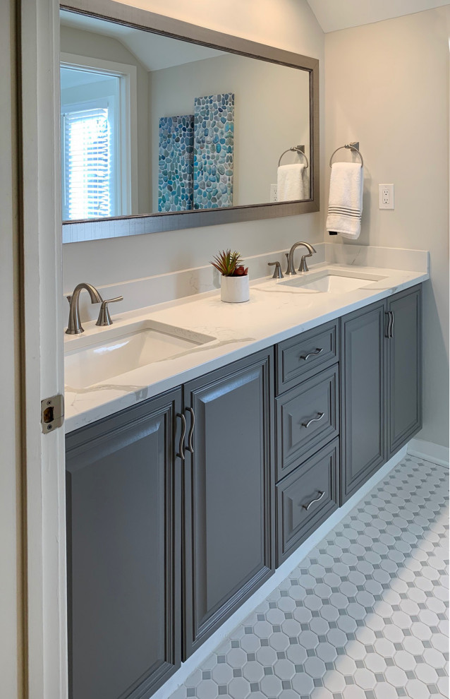 This is an example of a mid-sized contemporary kids bathroom with raised-panel cabinets, grey cabinets, an alcove tub, a shower/bathtub combo, a one-piece toilet, white tile, subway tile, white walls, marble floors, an undermount sink, engineered quartz benchtops, white floor, a shower curtain, white benchtops, a niche, a double vanity, a built-in vanity and vaulted.