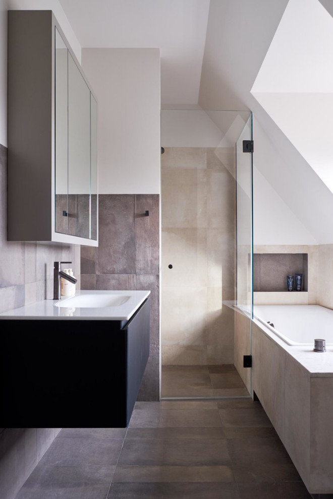 Small transitional master bathroom in London with glass-front cabinets, black cabinets, a drop-in tub, an open shower, gray tile, porcelain tile, porcelain floors, grey floor, a hinged shower door, a single vanity and a floating vanity.