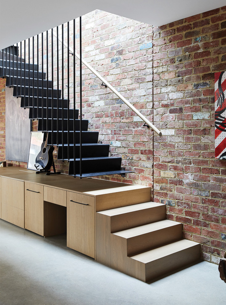 Inspiration for a mid-sized industrial metal l-shaped staircase in Melbourne with metal risers, wood railing and brick walls.