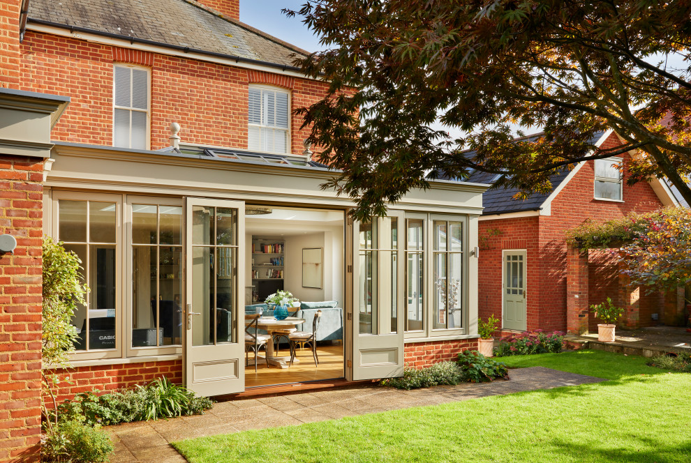 Kleiner, Halbschattiger Garten im Sommer, hinter dem Haus mit Sichtschutz und Betonboden in Essex