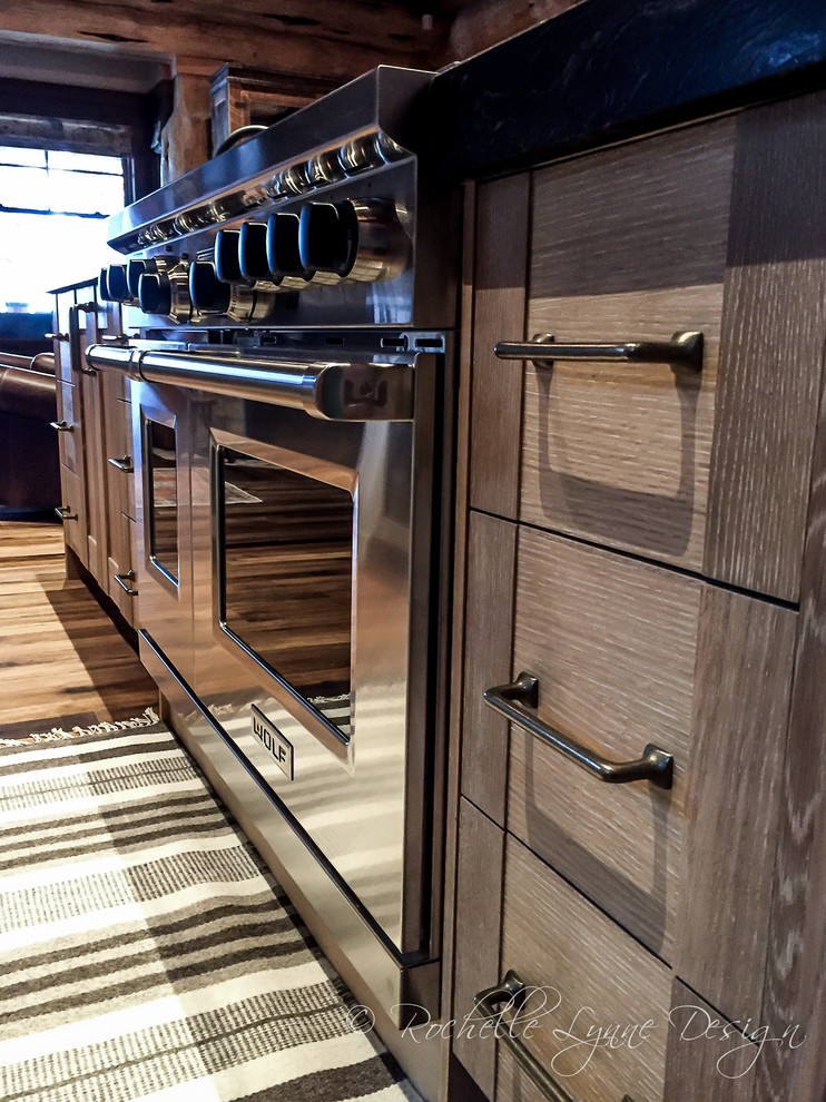 Mountain style l-shaped medium tone wood floor open concept kitchen photo in Calgary with shaker cabinets, distressed cabinets, granite countertops and two islands