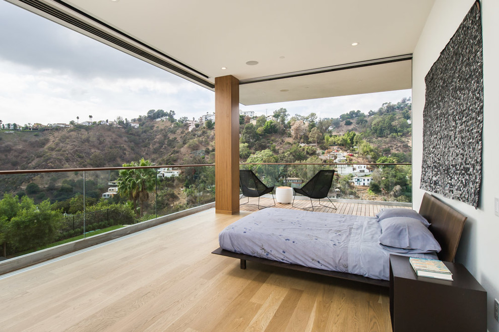 Design ideas for a contemporary bedroom in Los Angeles with white walls, light hardwood floors and no fireplace.