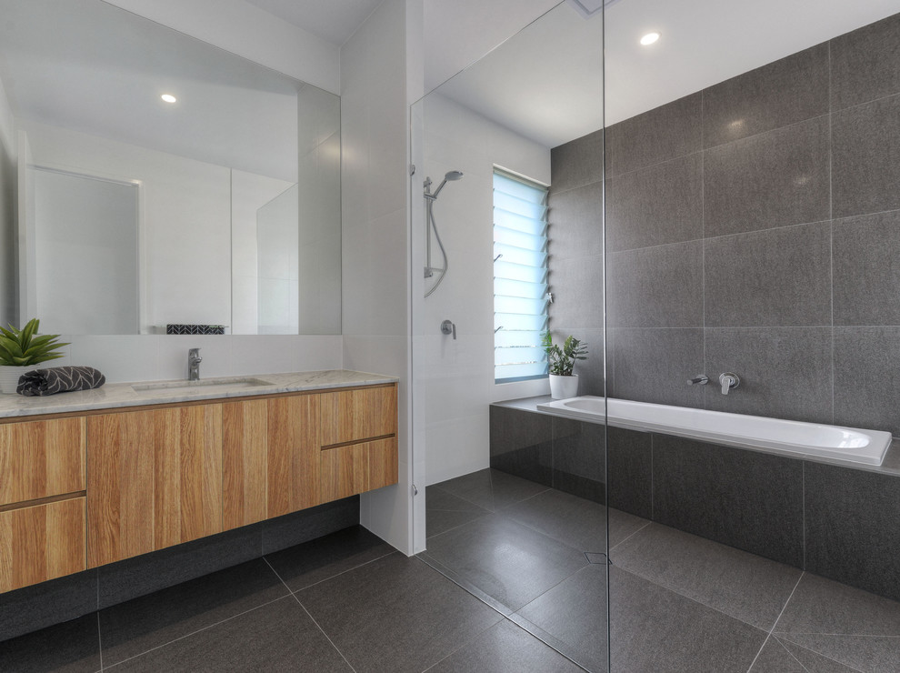 Inspiration for a transitional master bathroom in Brisbane with medium wood cabinets, an alcove tub, an open shower, black and white tile, ceramic tile, white walls, ceramic floors, an undermount sink and marble benchtops.
