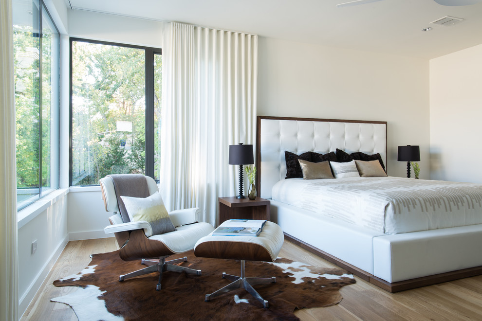 Photo of a mid-sized contemporary master bedroom in Dallas with white walls, light hardwood floors and no fireplace.