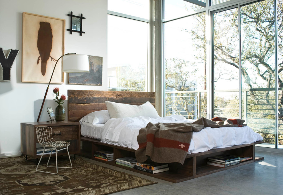 This is an example of an industrial bedroom in Los Angeles with white walls, concrete floors and grey floor.