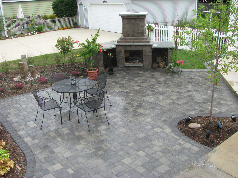 Photo of a mid-sized traditional backyard patio in Other with a fire feature, concrete pavers and no cover.
