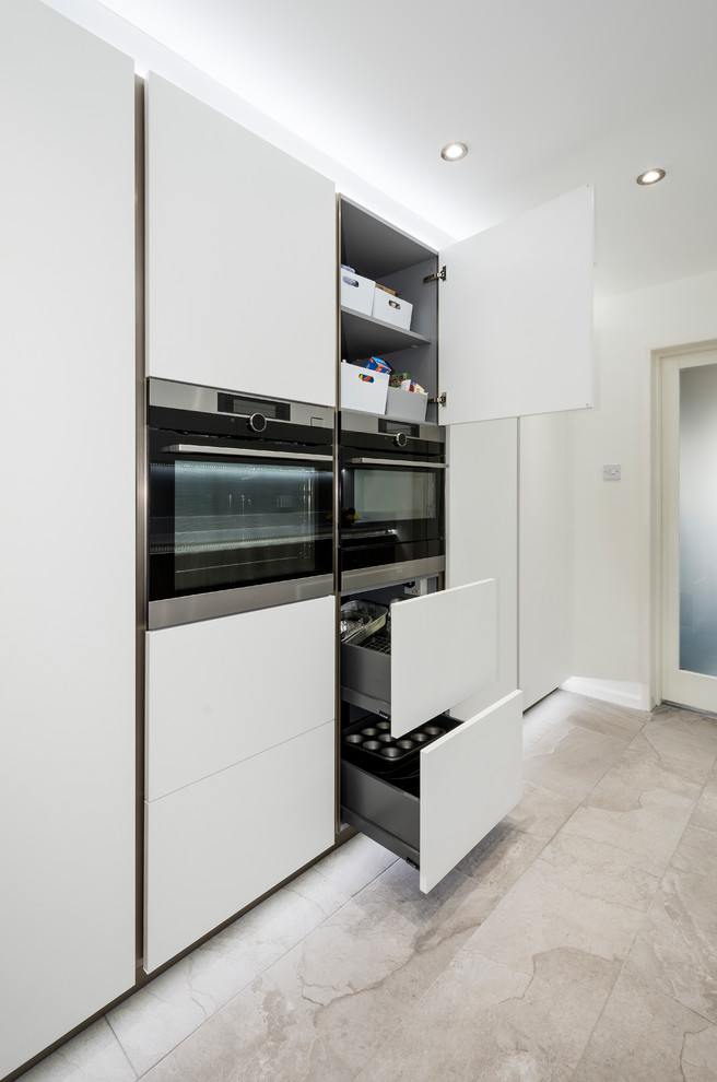 Inspiration for a small contemporary galley separate kitchen in Devon with an integrated sink, flat-panel cabinets, solid surface benchtops and white benchtop.