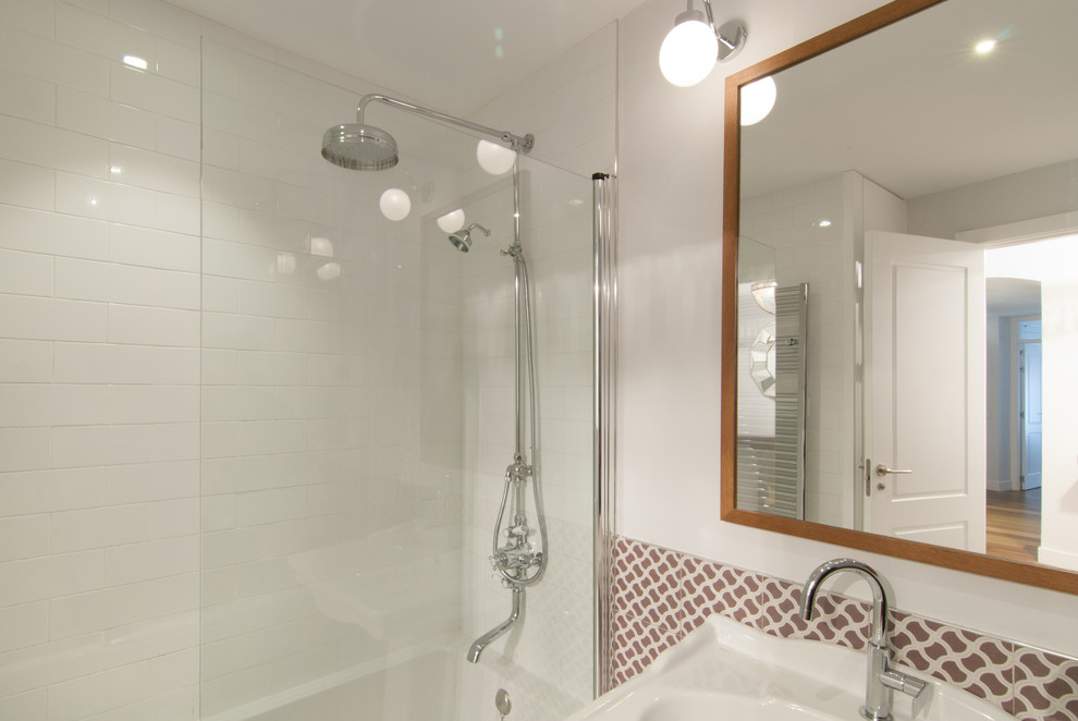 This is an example of a mid-sized transitional master bathroom in Madrid with a shower/bathtub combo, white walls, an alcove tub and a wall-mount sink.