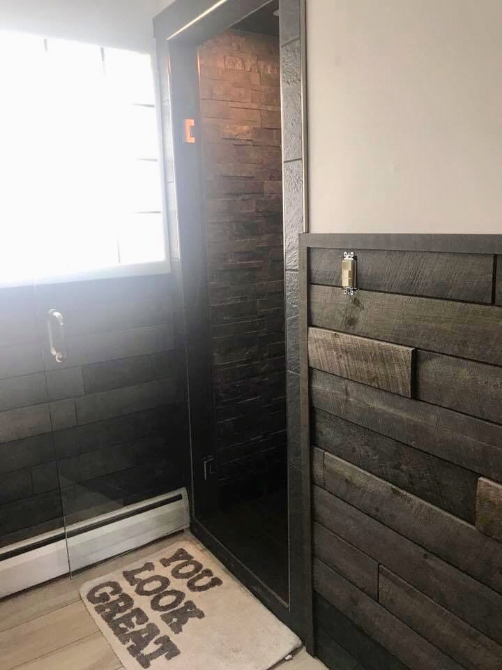 Photo of a country 3/4 bathroom in Other with flat-panel cabinets, black cabinets, an alcove shower, a two-piece toilet, white walls, porcelain floors, a vessel sink, engineered quartz benchtops, beige floor, a hinged shower door and beige benchtops.