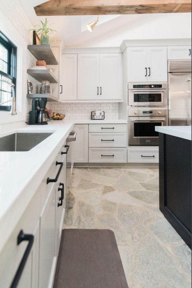 Inspiration for a large country u-shaped eat-in kitchen in Baltimore with an undermount sink, recessed-panel cabinets, grey cabinets, white splashback, subway tile splashback, stainless steel appliances, limestone floors, with island, grey floor, white benchtop, exposed beam and quartz benchtops.