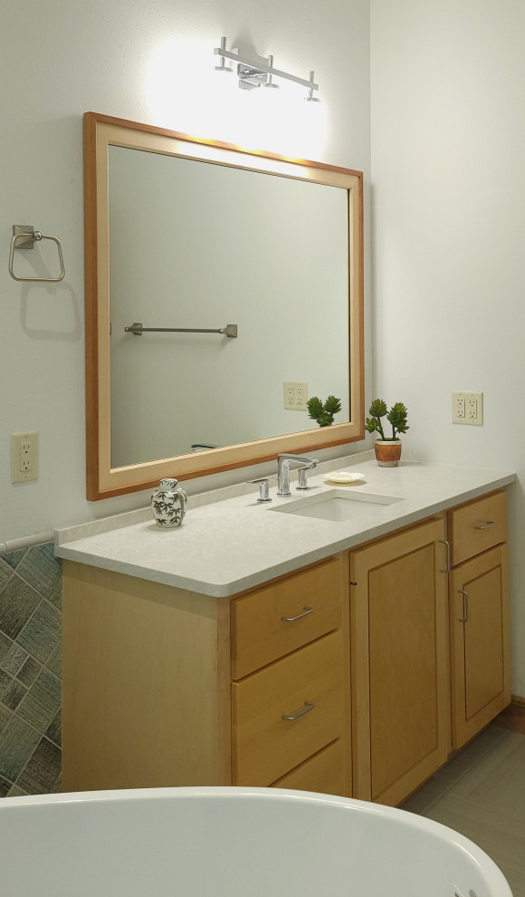 Cette image montre une salle de bain design en bois clair de taille moyenne avec un placard à porte shaker, une baignoire indépendante, une douche ouverte, WC suspendus, un carrelage vert, des carreaux de porcelaine, un mur blanc, un sol en carrelage de porcelaine, un lavabo encastré, un plan de toilette en quartz modifié, un sol beige, un plan de toilette blanc, meuble simple vasque et meuble-lavabo encastré.