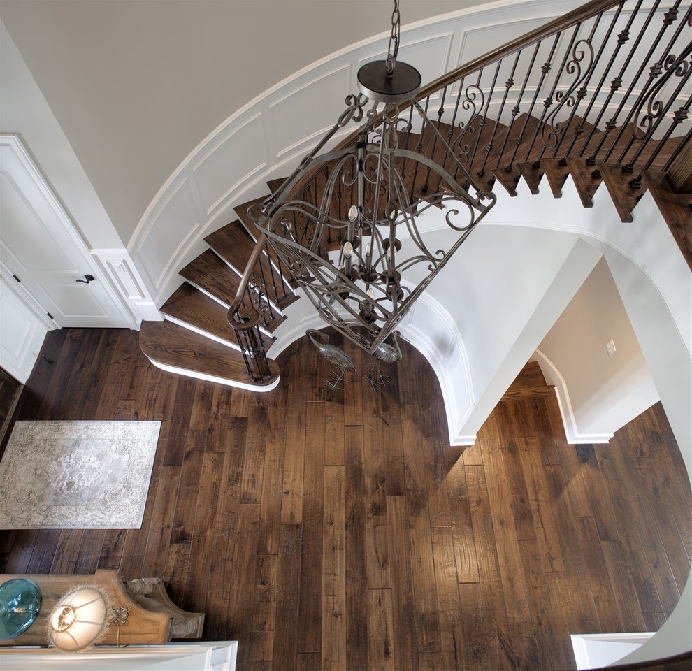 This is an example of a large traditional wood curved staircase in Atlanta with painted wood risers.