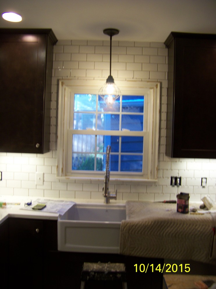 Eat-in kitchen - mid-sized rustic u-shaped porcelain tile eat-in kitchen idea in Indianapolis with a farmhouse sink, shaker cabinets, dark wood cabinets, wood countertops, white backsplash, ceramic backsplash, stainless steel appliances and an island