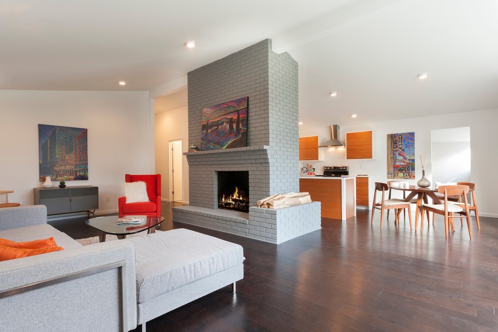 Mid-sized midcentury formal loft-style living room in Other with white walls, dark hardwood floors, a standard fireplace, a brick fireplace surround and no tv.