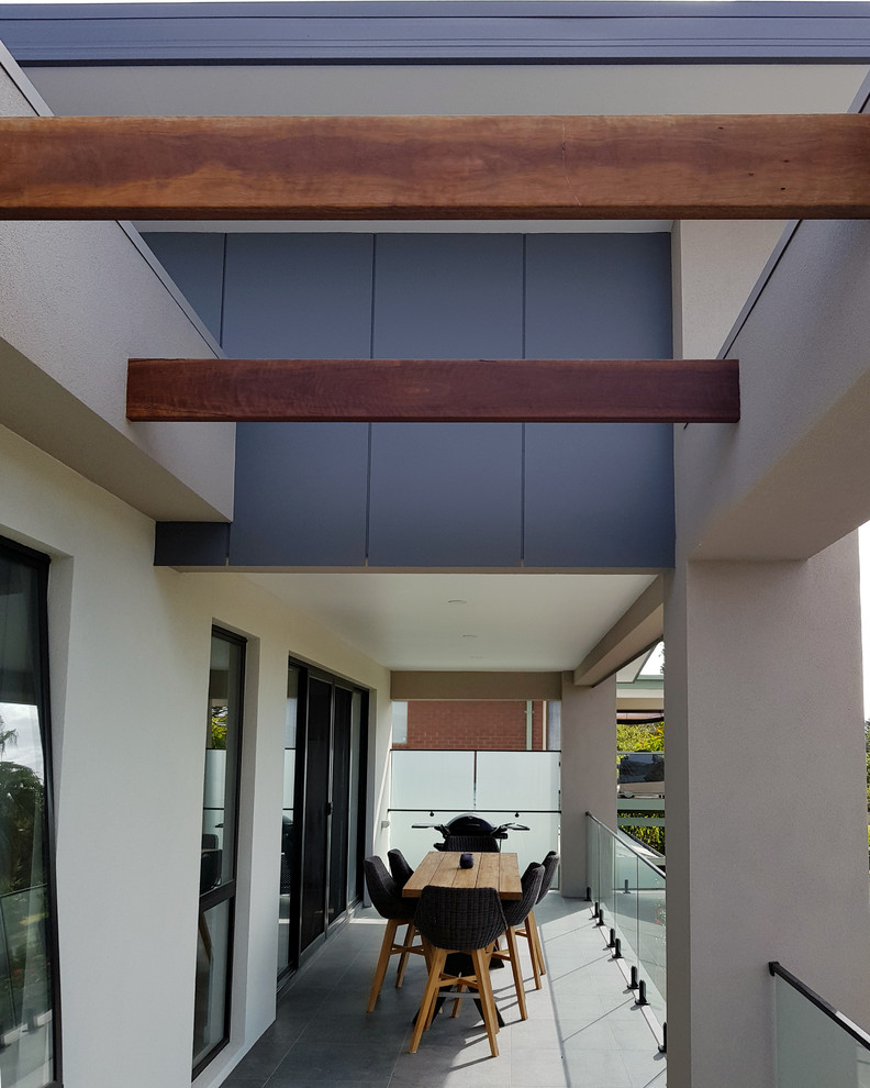 This is an example of a mid-sized contemporary balcony in Melbourne with a pergola and wood railing.