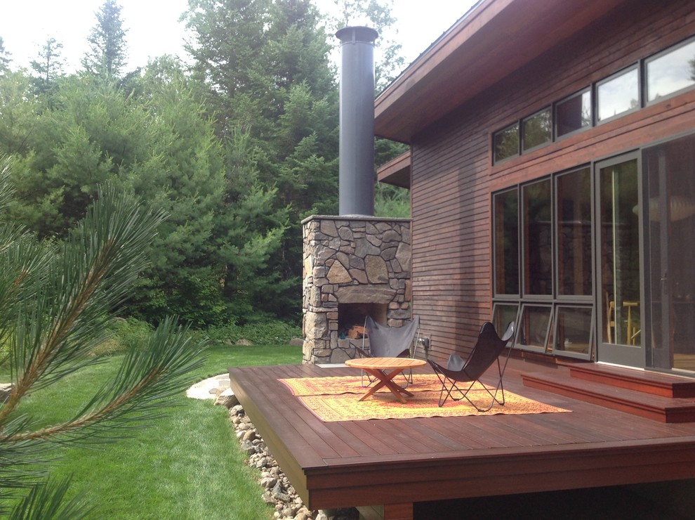 Inspiration for a mid-sized country backyard deck in Other with a fire feature and a roof extension.