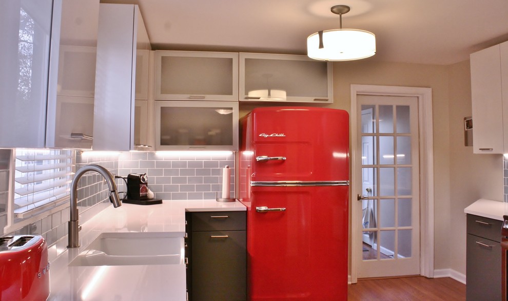 Example of a mid-sized minimalist u-shaped medium tone wood floor kitchen design with a farmhouse sink, flat-panel cabinets, gray cabinets, quartz countertops, blue backsplash, subway tile backsplash and colored appliances