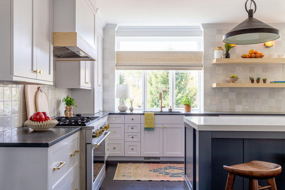 Design ideas for a mid-sized eclectic u-shaped separate kitchen in Bridgeport with a drop-in sink, shaker cabinets, blue cabinets, granite benchtops, white splashback, porcelain splashback, stainless steel appliances, cement tiles, with island, black floor, black benchtop and wood.