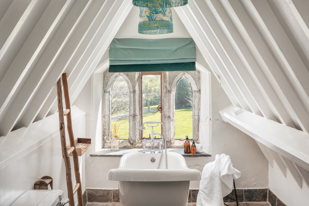 Immagine di una stanza da bagno per bambini classica di medie dimensioni con vasca con piedi a zampa di leone, WC monopezzo, pareti blu, pavimento grigio e pareti in mattoni
