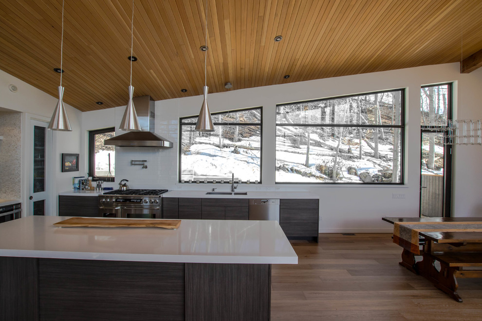 Inspiration for a huge craftsman galley light wood floor eat-in kitchen remodel in Toronto with an undermount sink, flat-panel cabinets, gray cabinets, quartz countertops, white backsplash, ceramic backsplash, stainless steel appliances and an island