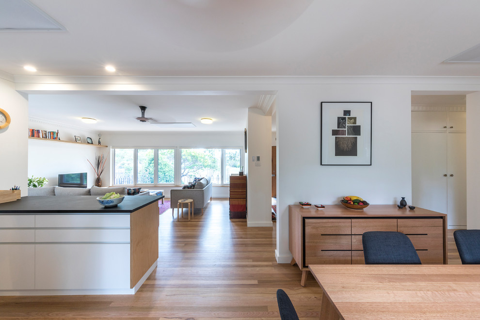 Mid-sized contemporary open plan dining in Canberra - Queanbeyan with white walls, light hardwood floors and yellow floor.
