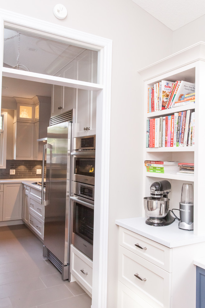 Inspiration for a large transitional u-shaped dark wood floor and brown floor kitchen pantry remodel in Toronto with recessed-panel cabinets, white cabinets, quartz countertops, gray backsplash, stainless steel appliances, an island and white countertops