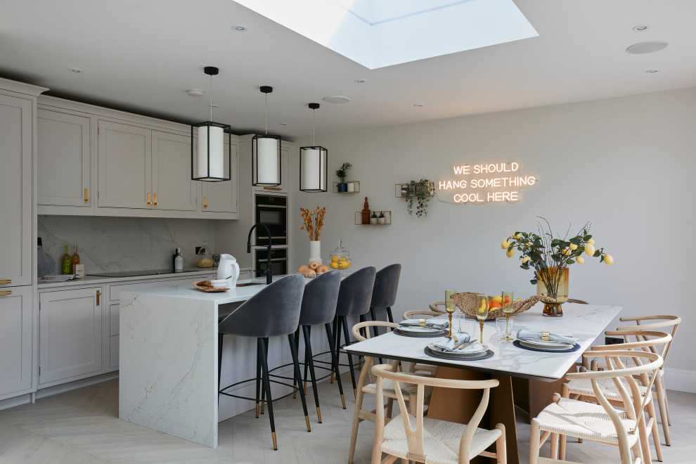 Inspiration for a transitional galley eat-in kitchen in London with an undermount sink, shaker cabinets, grey cabinets, marble benchtops, multi-coloured splashback, marble splashback, panelled appliances, light hardwood floors, a peninsula, beige floor and multi-coloured benchtop.