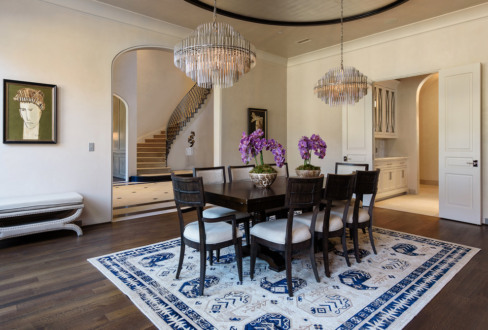 This is an example of a large mediterranean separate dining room in Dallas with white walls, dark hardwood floors, brown floor and no fireplace.