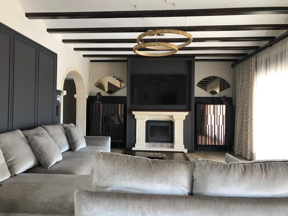 Пример оригинального дизайна: большая гостиная комната в классическом стиле с коричневыми стенами, светлым паркетным полом, стандартным камином, фасадом камина из камня, телевизором на стене и балками на потолке