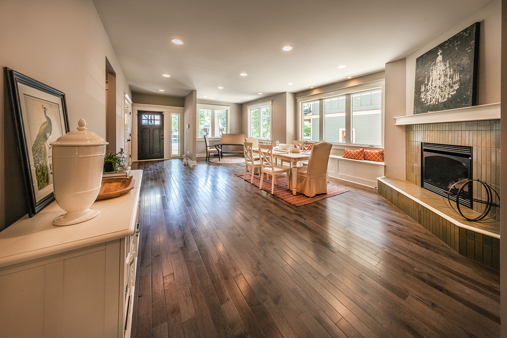 Large arts and crafts open plan dining in Indianapolis with grey walls, medium hardwood floors, a corner fireplace and a tile fireplace surround.