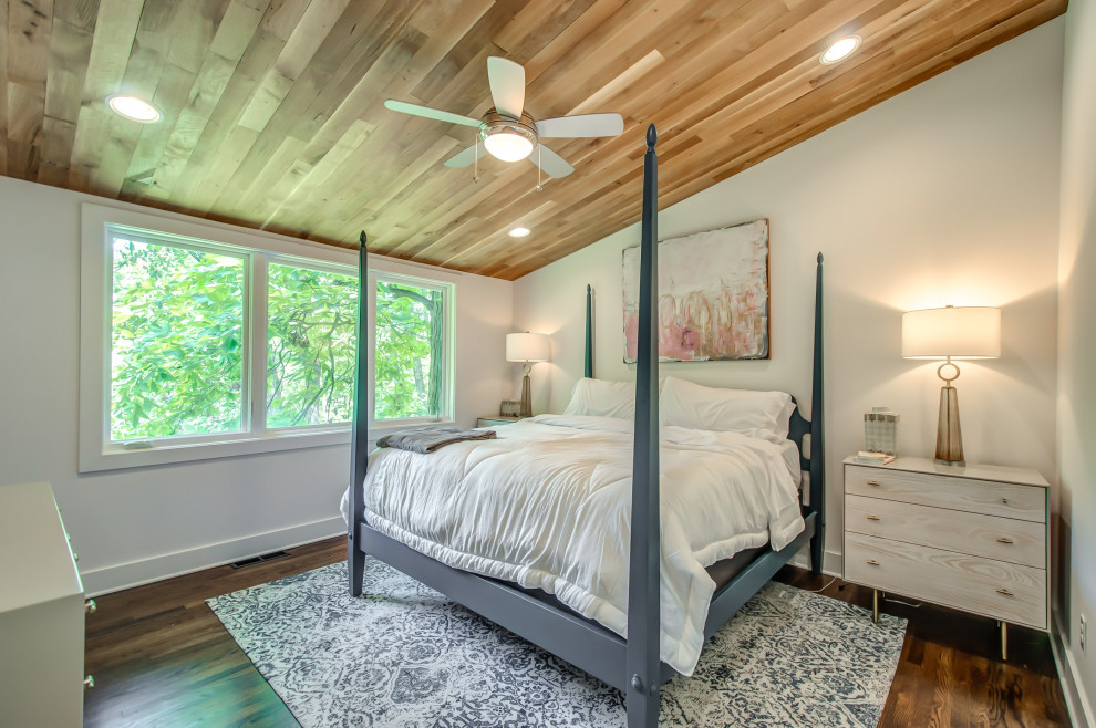 Photo of a transitional guest bedroom in Nashville with white walls, medium hardwood floors, no fireplace and brown floor.
