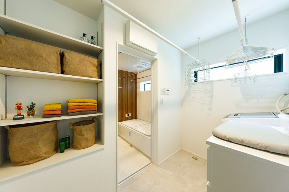 東京都下にある高級な中くらいなインダストリアルスタイルのおしゃれな洗濯室 (白い壁、淡色無垢フローリング、ベージュの床、クロスの天井、壁紙、白い天井) の写真