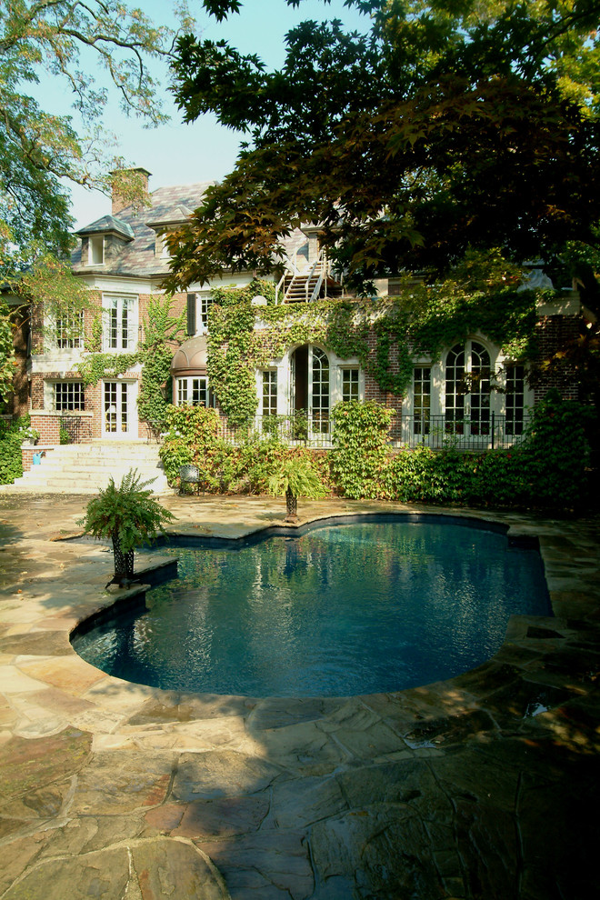 Mid-sized traditional backyard custom-shaped natural pool in Toronto with natural stone pavers.