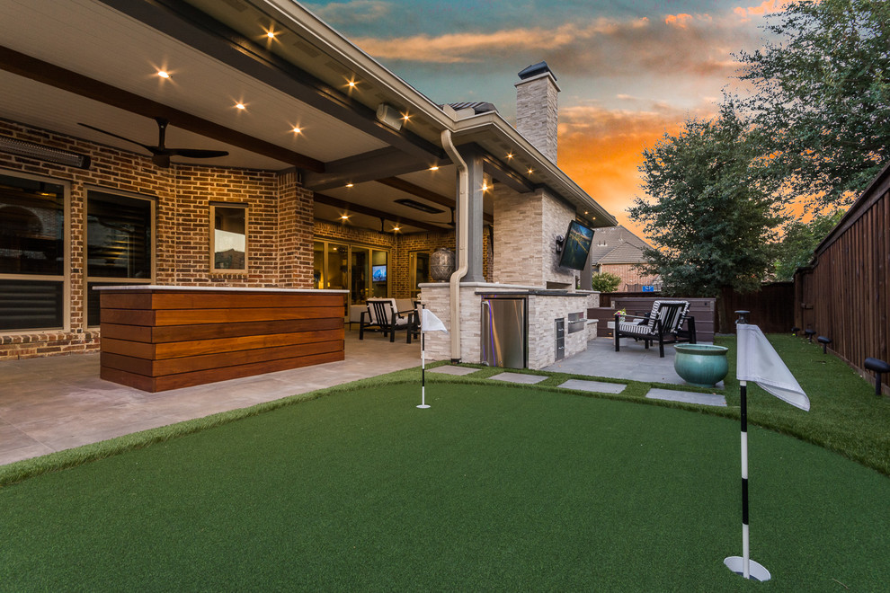 Expansive transitional backyard patio in Dallas with tile and a roof extension.