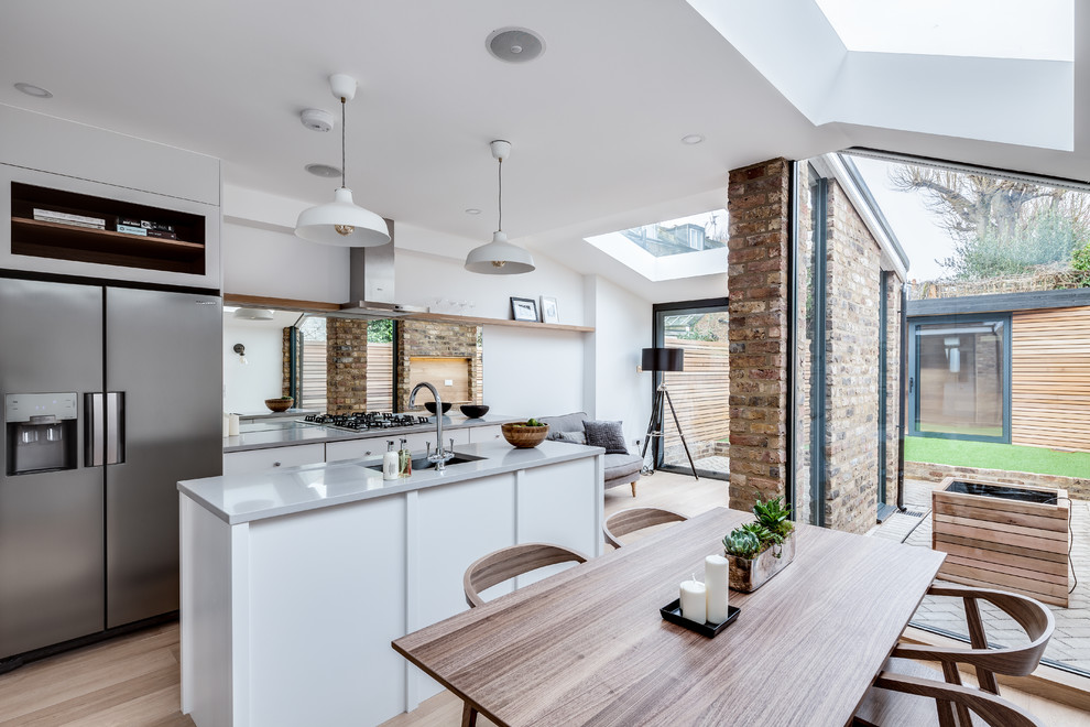 This is an example of a scandinavian kitchen/dining combo in London with white walls and light hardwood floors.