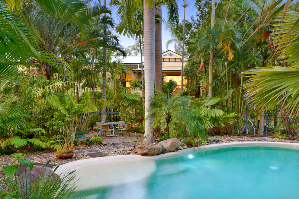 Photo of a large tropical backyard kidney-shaped pool in Brisbane with gravel.