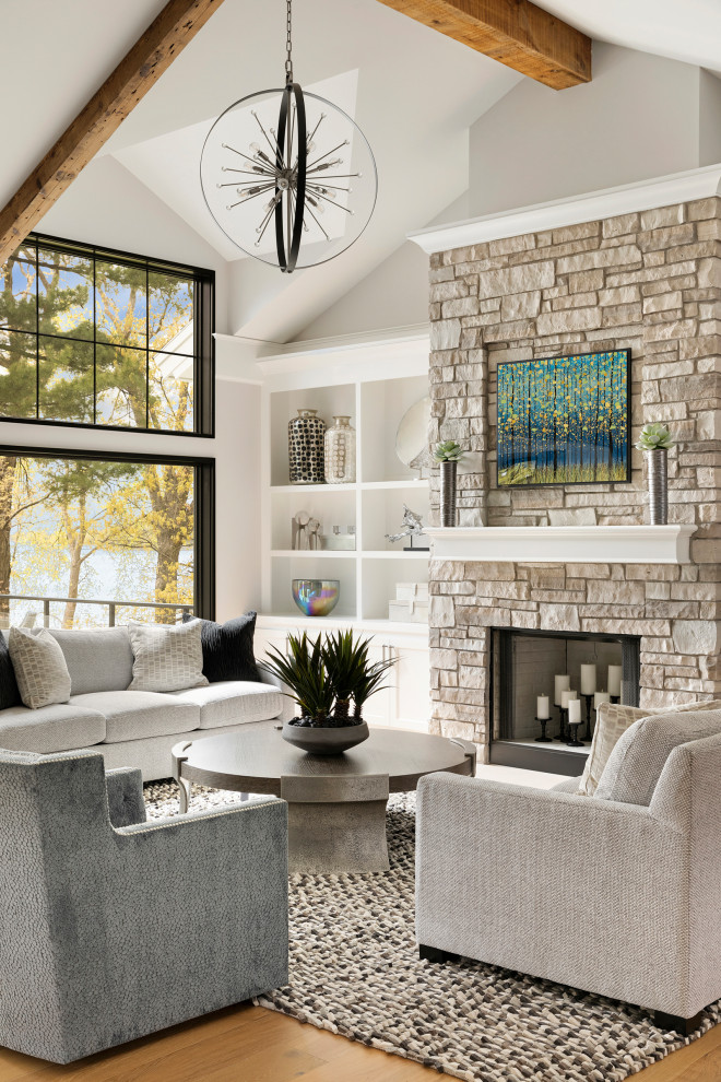 Inspiration for an expansive traditional open plan games room in Minneapolis with grey walls, light hardwood flooring, a stone fireplace surround and exposed beams.