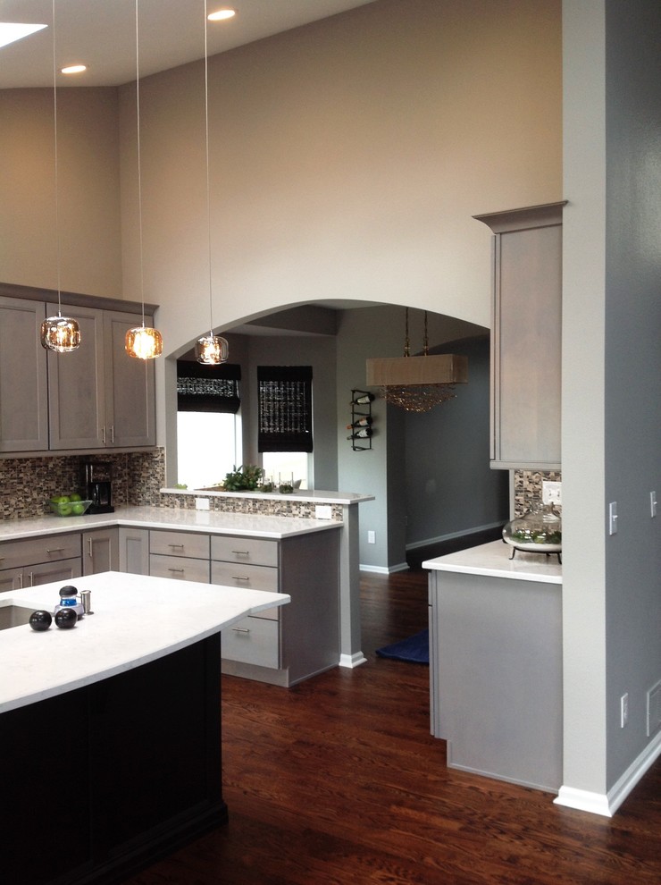 Example of a dark wood floor eat-in kitchen design in Denver with recessed-panel cabinets, gray cabinets, mosaic tile backsplash and an island